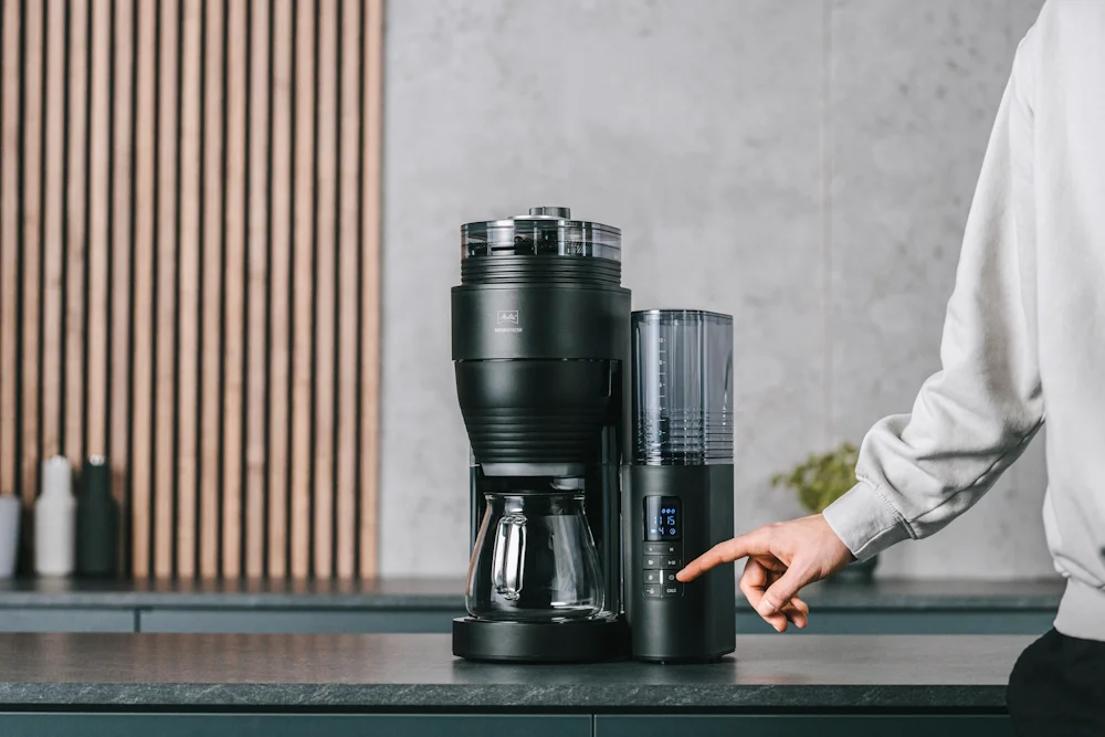 Image d'une personne qui regle le niveau de mouture du café sur une cafetière electrique Aromafresh
