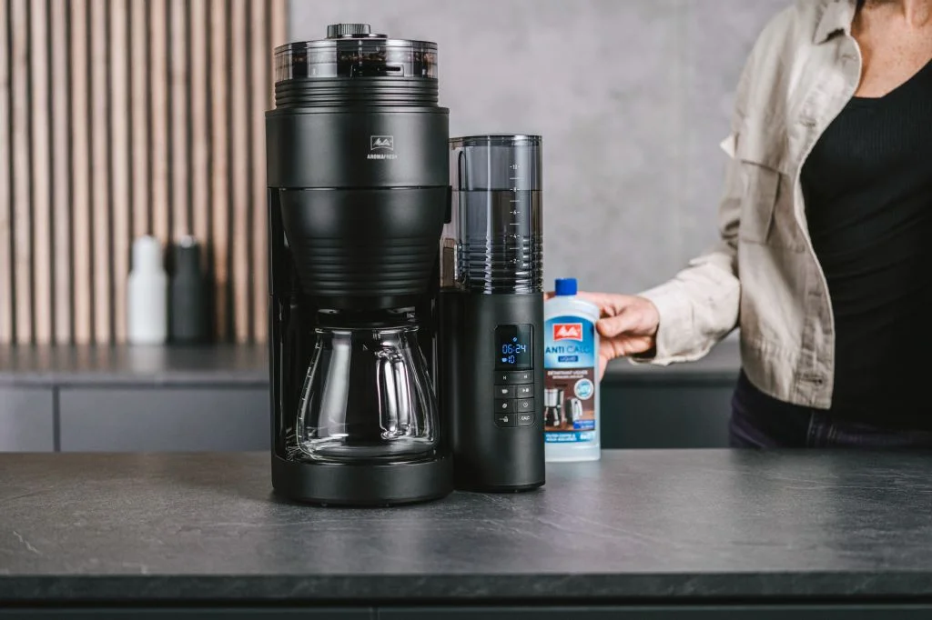 Image d'une personne qui s'apprête à lancer le programme de détartrage de sa  cafetière electrique Aromafresh