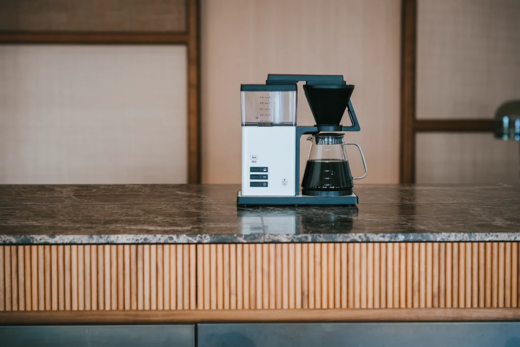 Melitta filter coffee machine on a marble table.