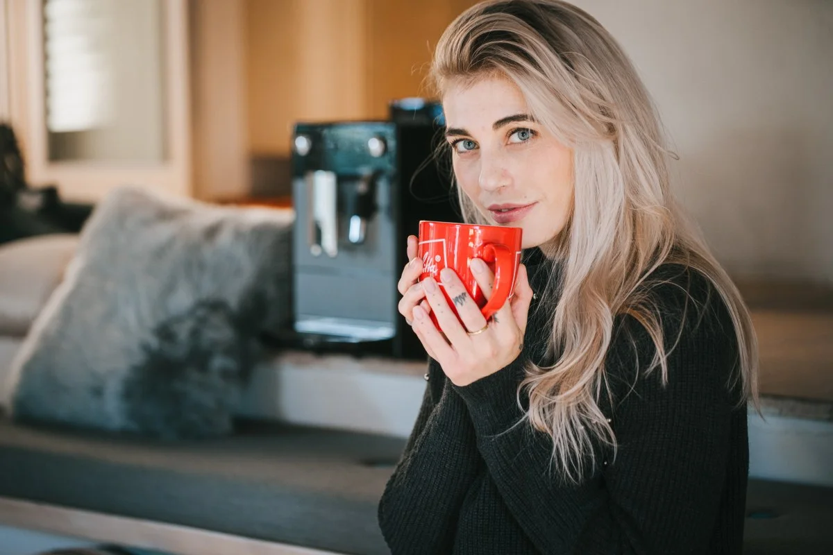 Woman drinking Melitta Coffee, background Melitta Avanza 