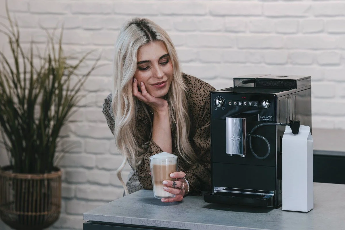 Melitta Latticia OT met een vrouw die geniet van een vers gezette koffie