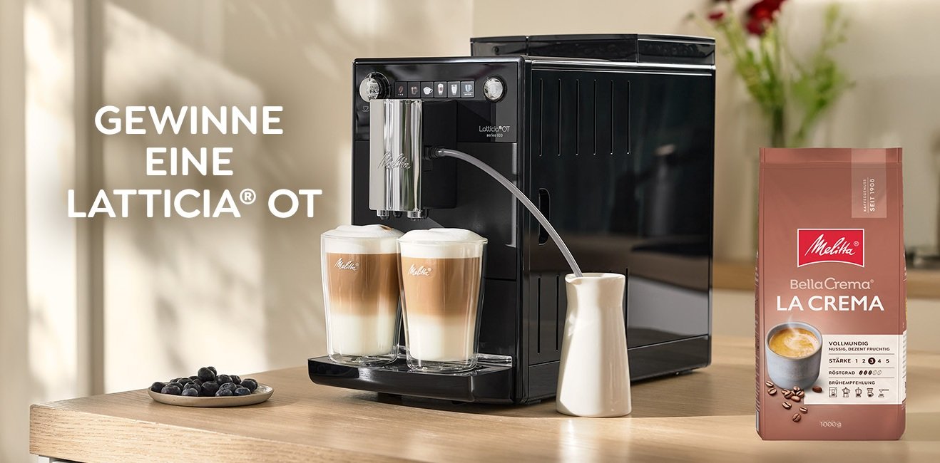 Latticia® OT steht auf der Kuchenzeile mit zwei Latte Macchiato und einer PackungMelitta® BellaCrema® La Crema Kaffeebohnen