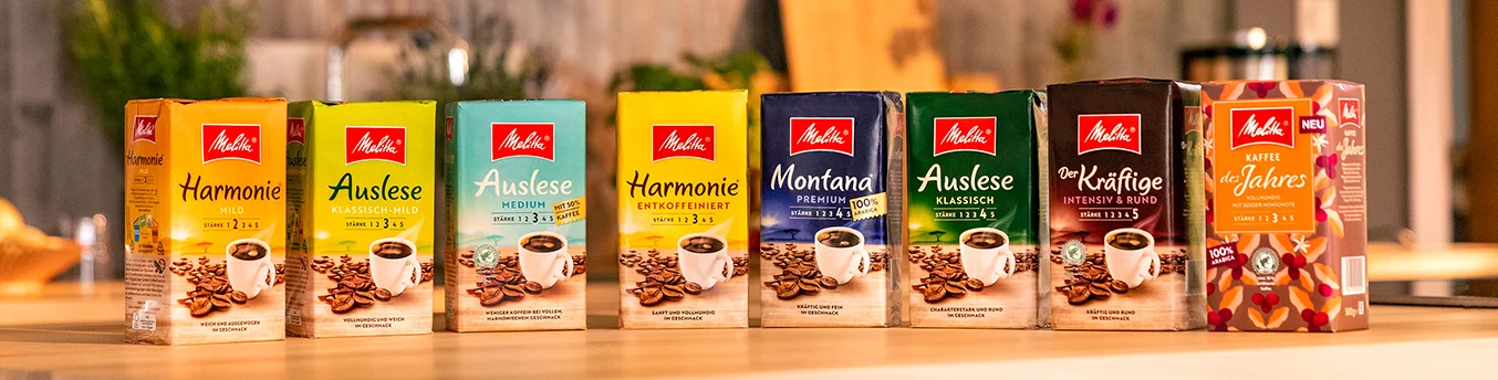 Melitta gemahlene Kaffeesorten in einer Reihe auf einer hölzernen Küchentheke
