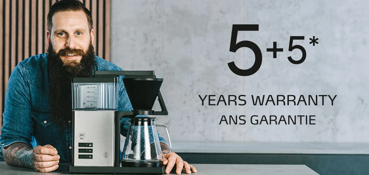 Man presenting our Melitta One coffee maker with a 10-year warranty