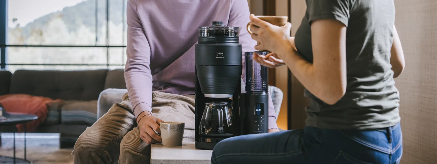 Deux personnes boivent du café à côté de la cafetière filtre Melitta AromaFresh Pro