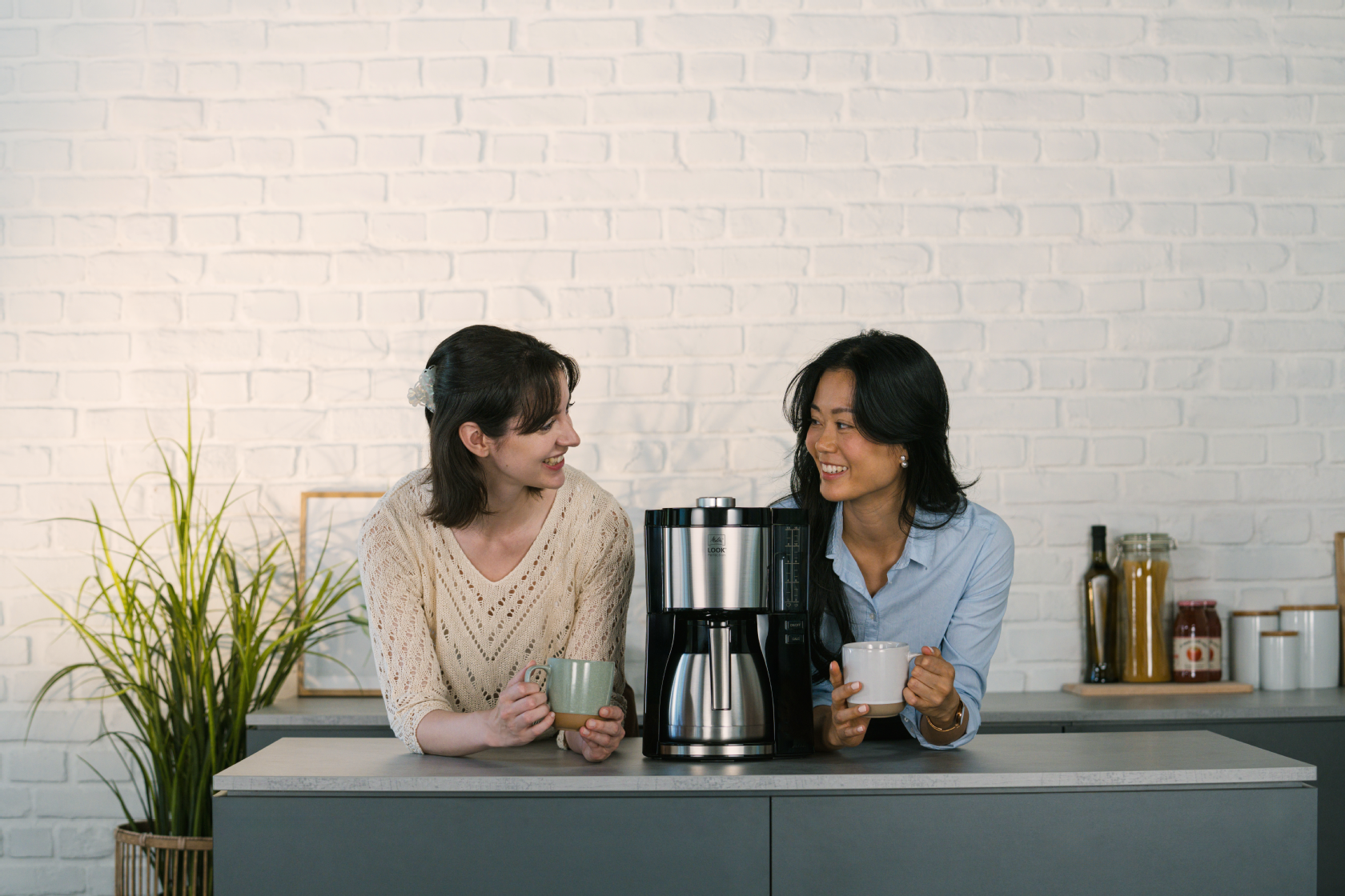Zwei Frauen genießen Kaffee neben der Melitta® LOOK® Therm Perfection Filterkaffeemaschine 