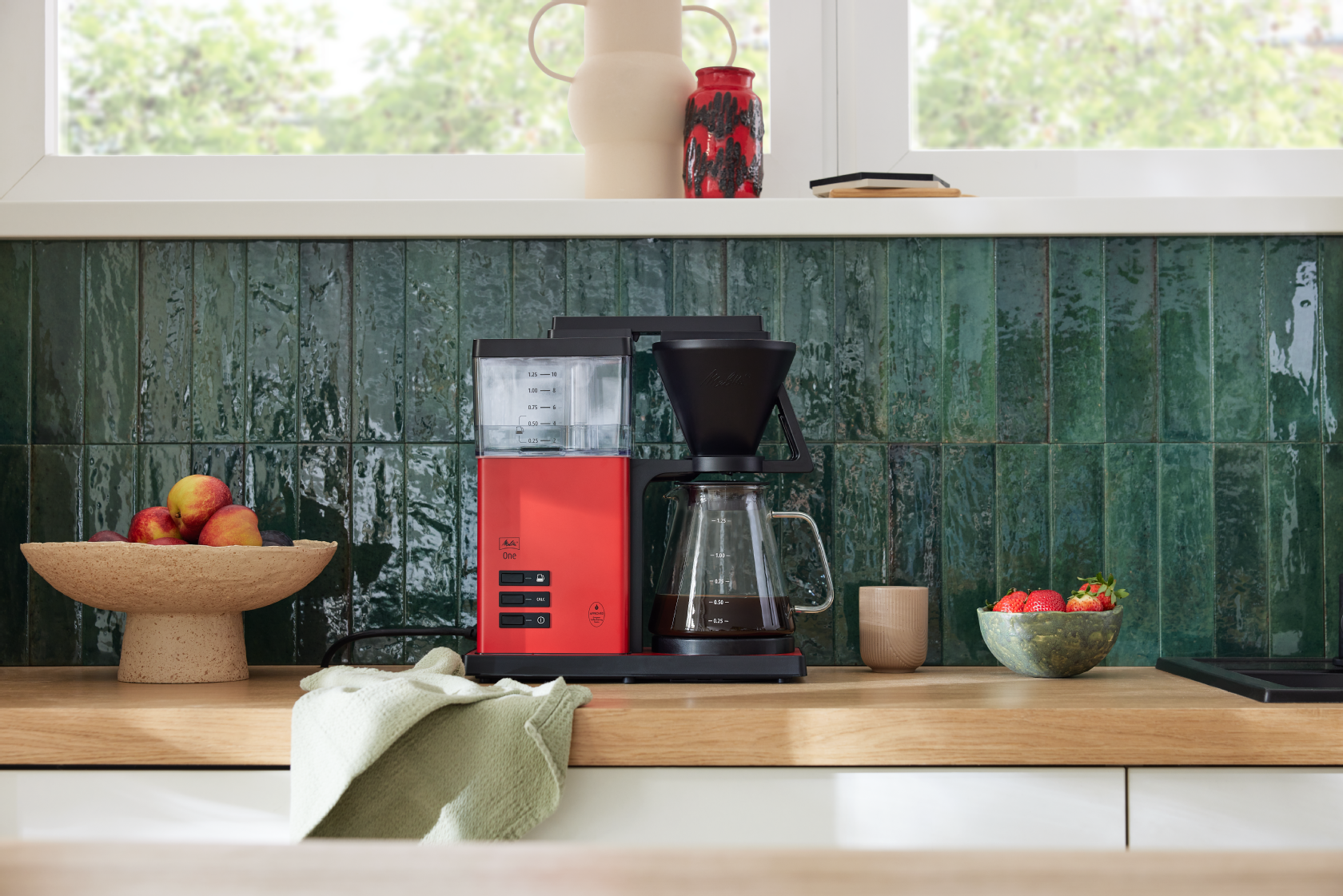 Rød Melitta ONE® filterkaffemaskine med glaskande i et moderne køkken
