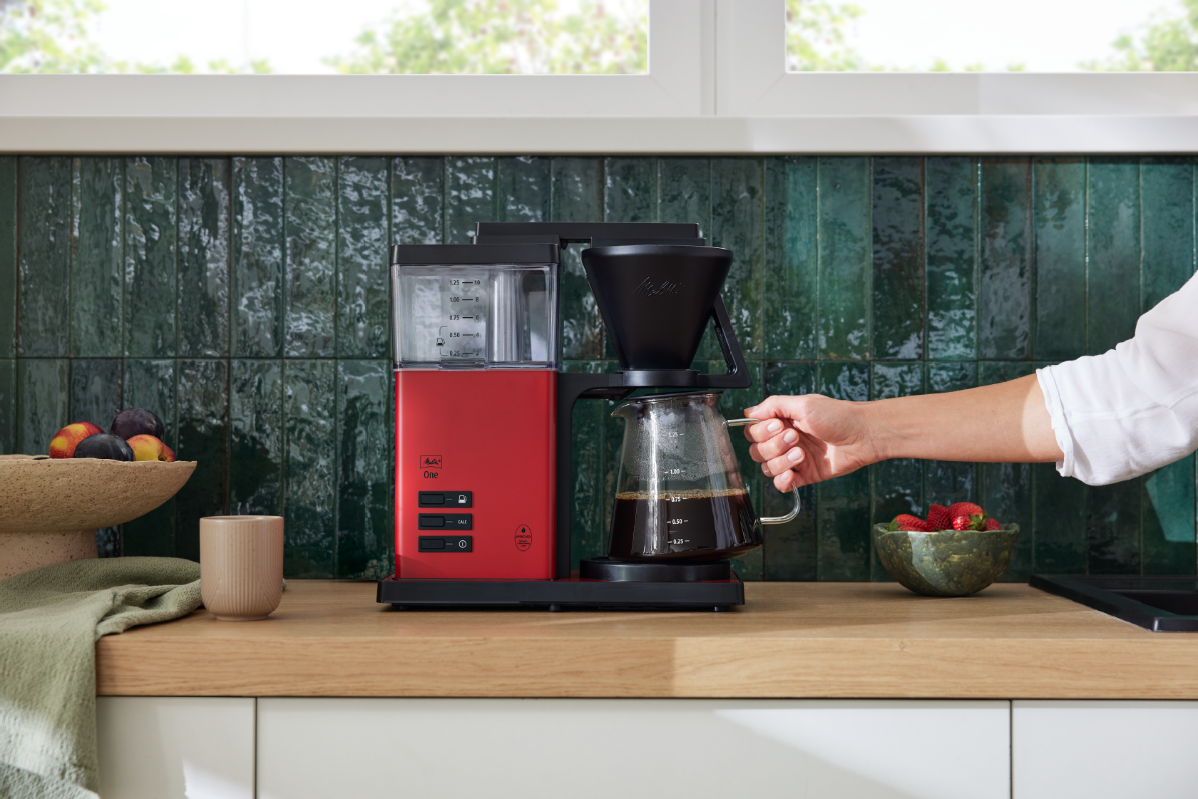 Rød Melitta ONE® filterkaffemaskine med glaskande i et moderne køkken