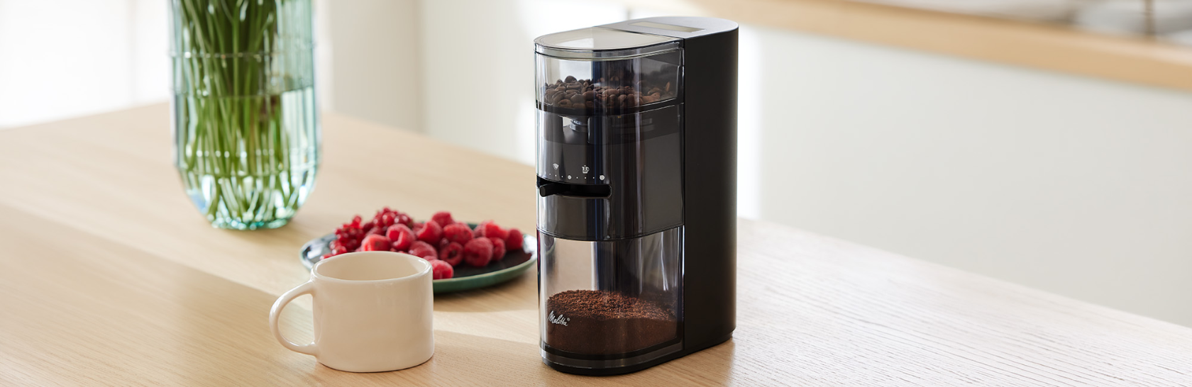 Melitta Linea® Kaffeemühle in Schwarz auf Küchentresen in heller moderner Küche.