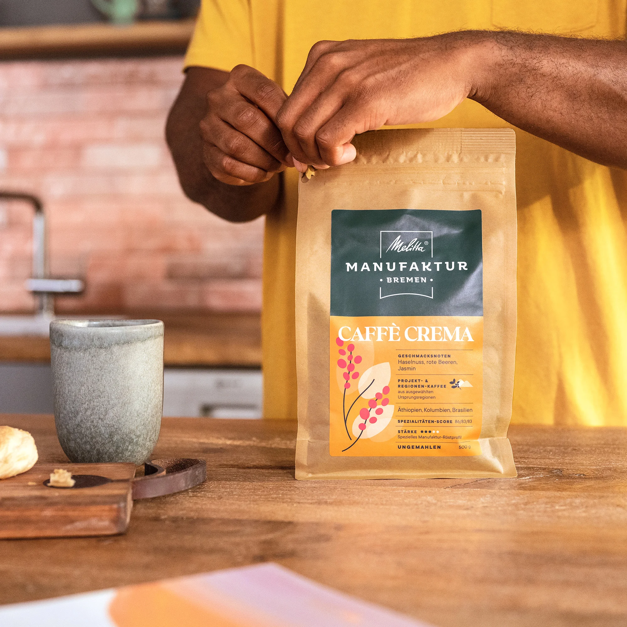 Mann öffnet Packung eines Manufaktur-Kaffees Caffé Crema