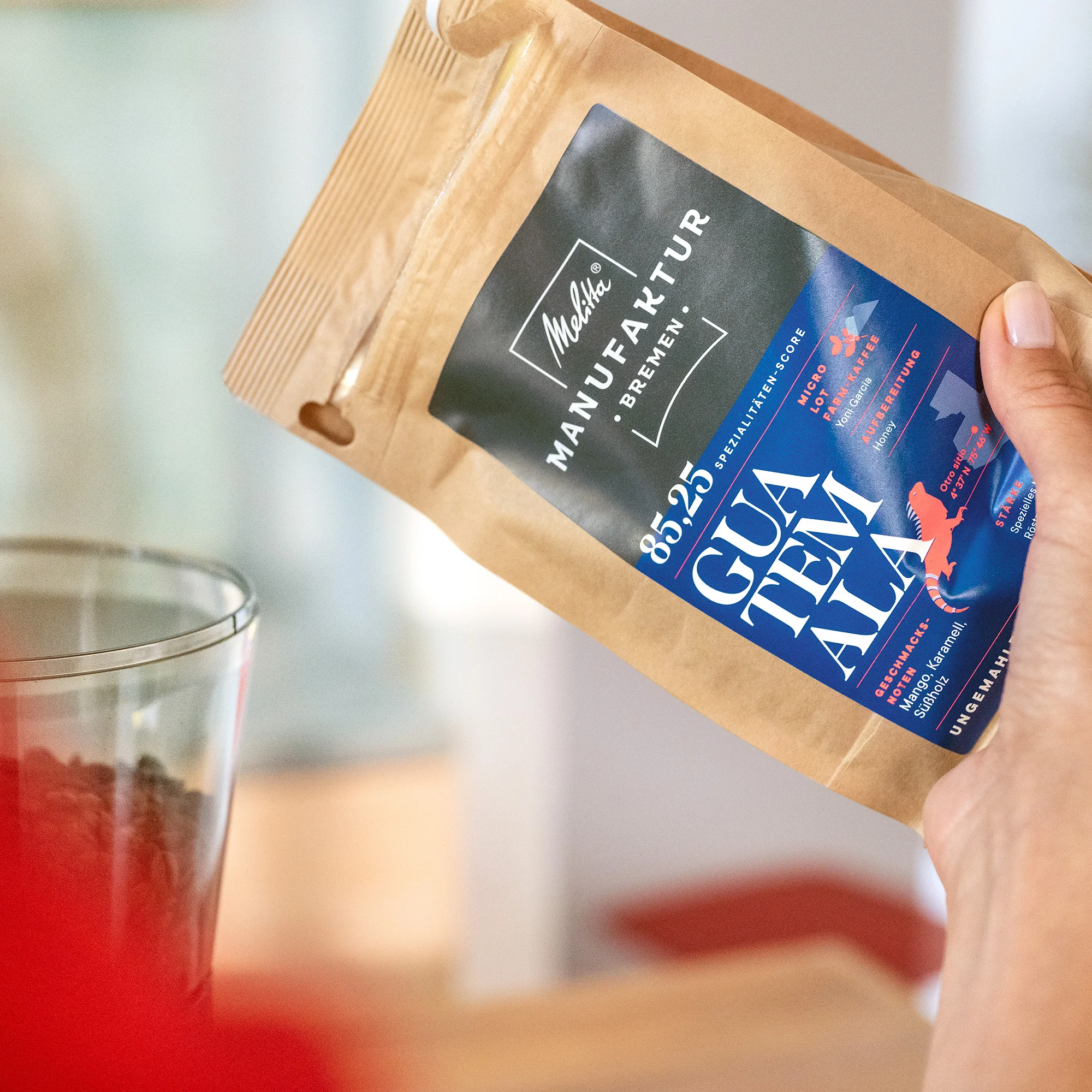 eine Hand schüttet Melitta Manufakturkaffee Guatemela in eine Kaffeemühle