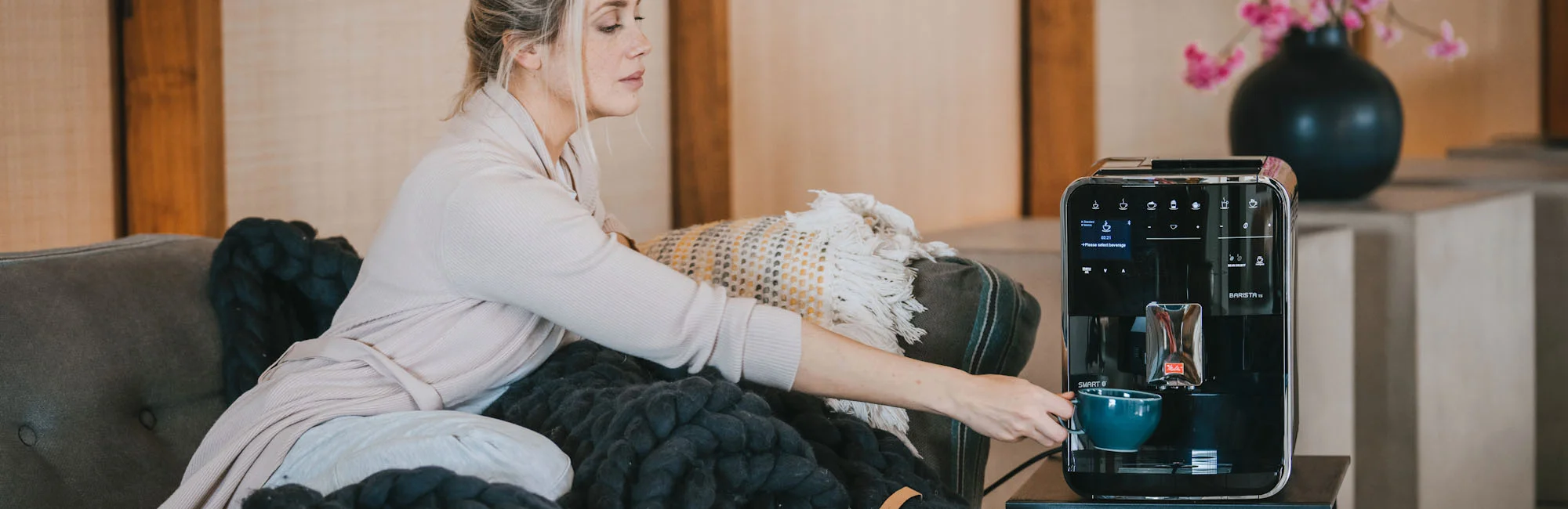 Photo of a woman in pajamas getting ready to have a large bowl of coffee thanks to our Barista automatic machine which has a quiet grinder for a gentle awakening