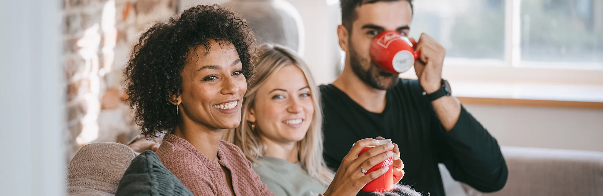 Models trinken Melitta Kaffee auf einer Couch