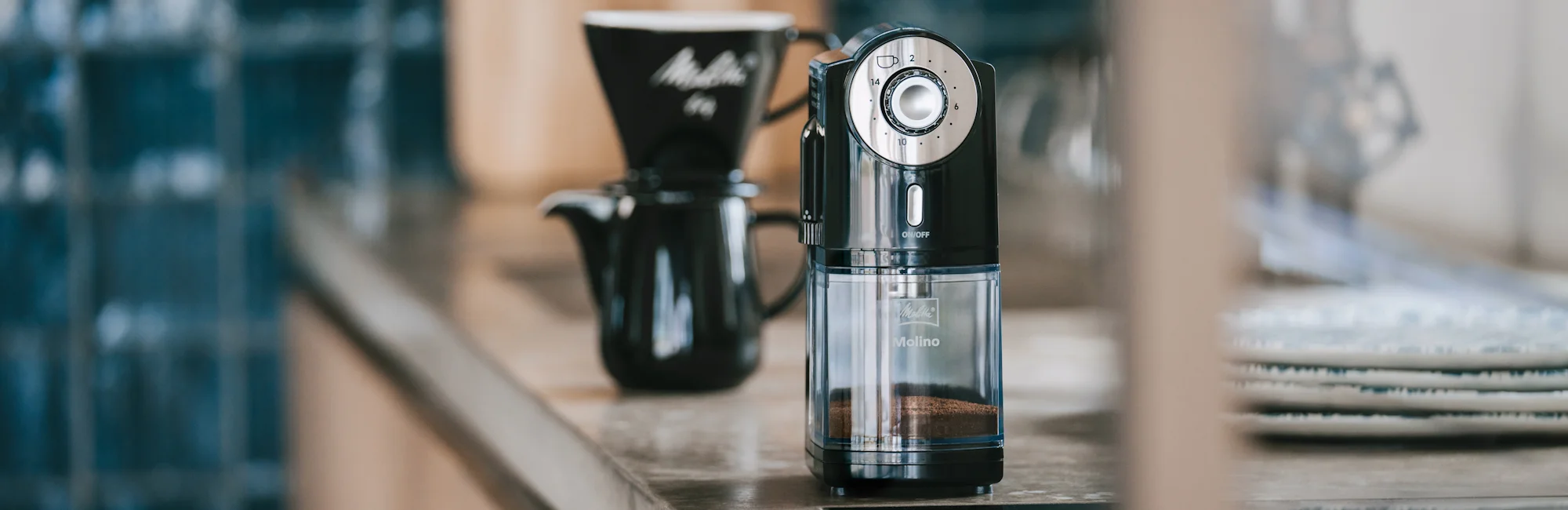 Image of our Molino coffee mill, a carafe, and a black porcelain filter holder.