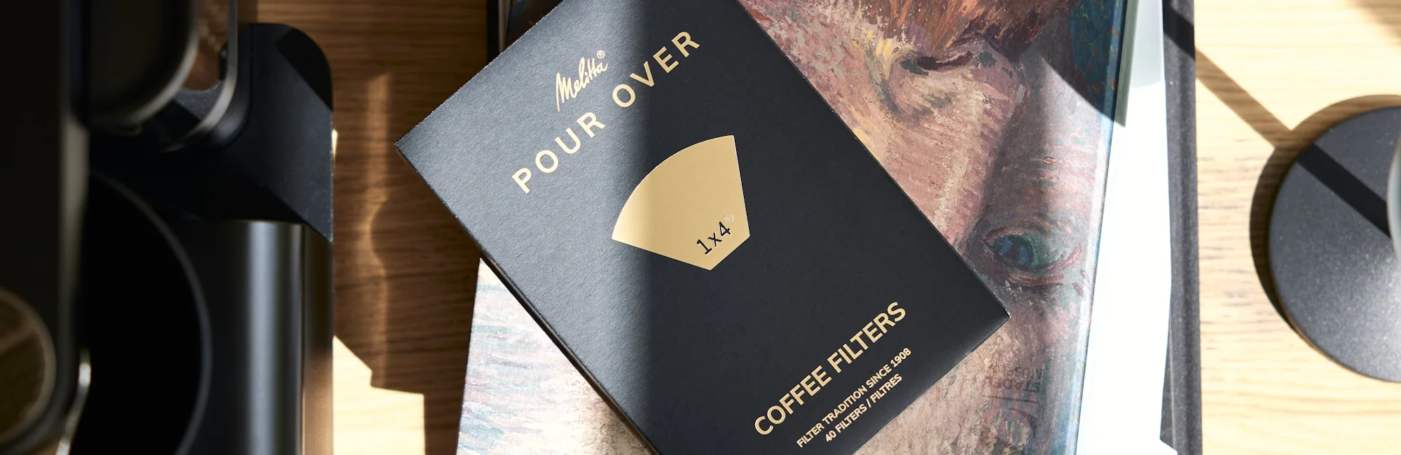 Afbeelding van een doos met filters uit ons assortiment, genaamd Pour Over, in een prachtige zwart-gouden behuizing.