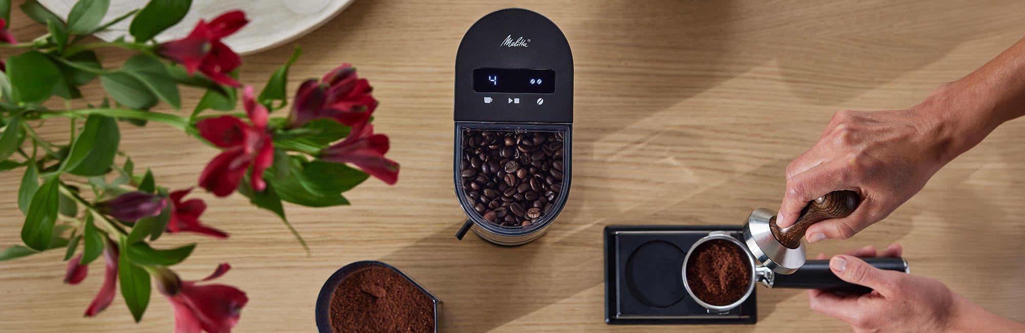 Melitta Linea® Kaffeemühle mit Kaffeebohnen und frisch gemahlenem Kaffee für den Siebträger.
