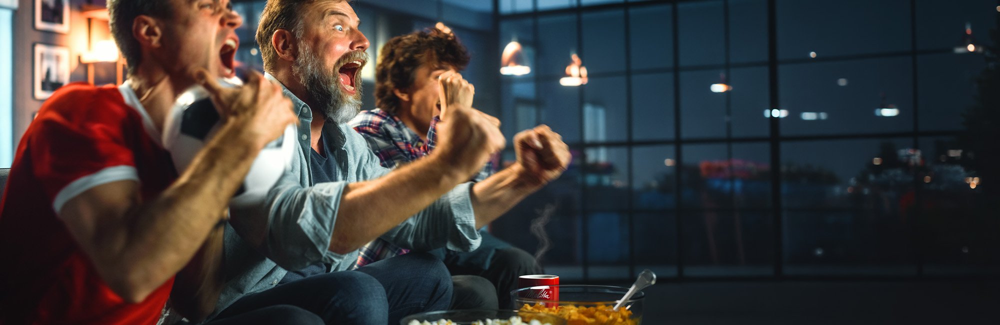 Männer freuen sich vor dem Fernseher beim Fußball