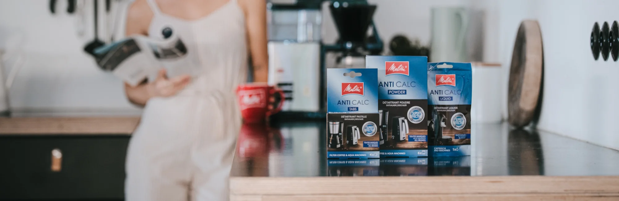 Image of 3 of our descalers (tablet, powder, and liquid) placed on a kitchen countertop.