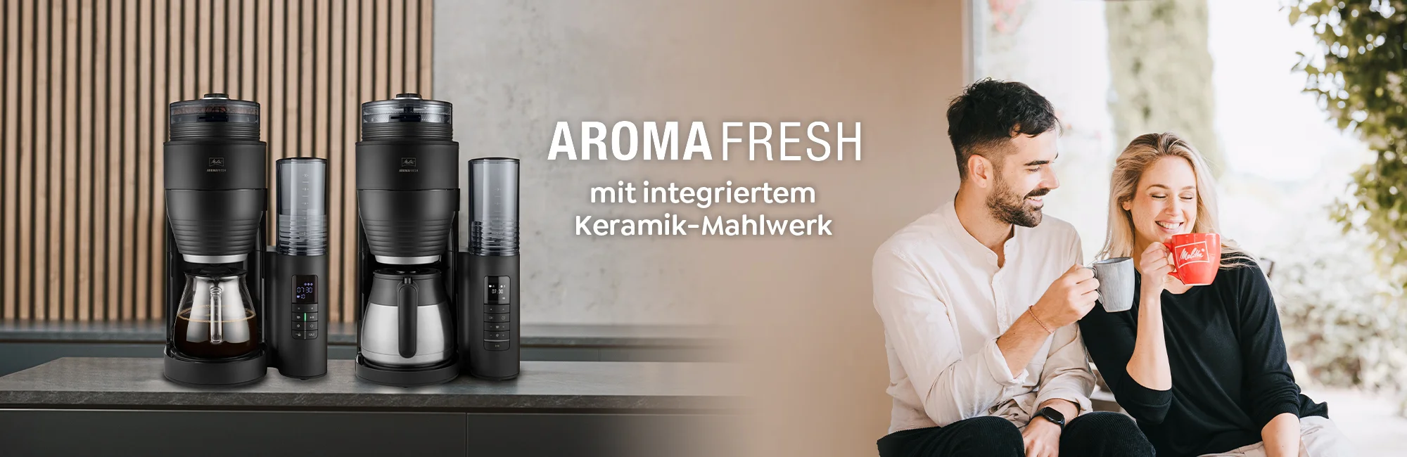 Zwei Melitta AromaFresh Filterkaffeemaschinen auf einer Arbeitsplatte neben einem lächelnden Paar mit Kaffeetassen
