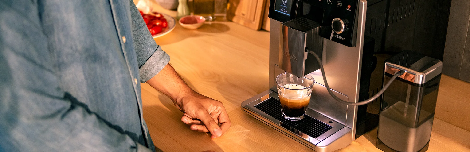 Kaffeevollautomat bereitet einen Kaffee zu, Kaffee läuft in ein Glas