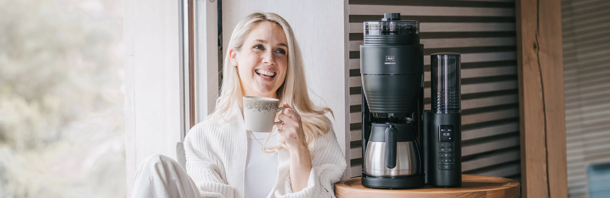 Frau trinkt Kaffee neben einer Melitta AromaFresh Therm Pro