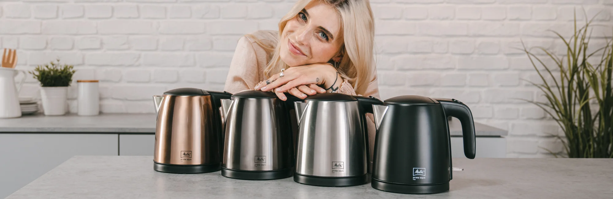 Image of a woman presenting a part of our range of kettles.