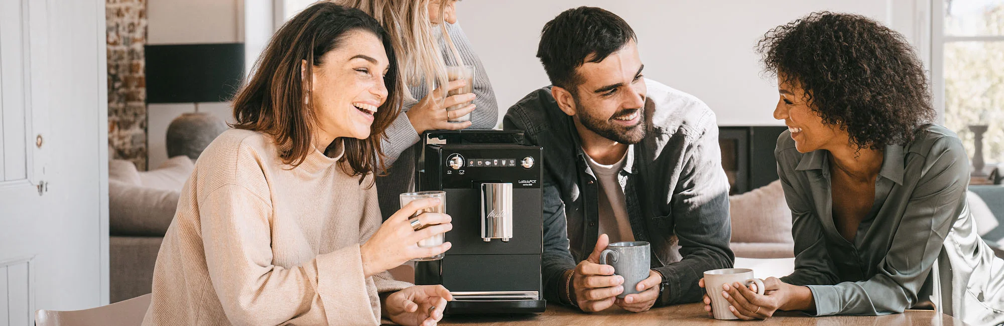 Photo of 4 friends enjoying a coffee around our Latticia One Touch automatic machine