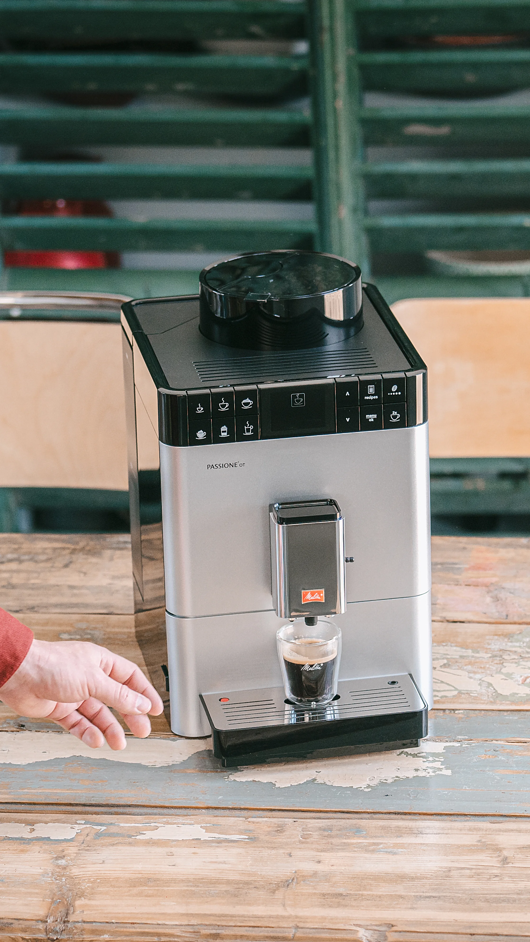 Melitta Passione OT bereitet einen Espresso zu, eine Hand greift zur Tasse