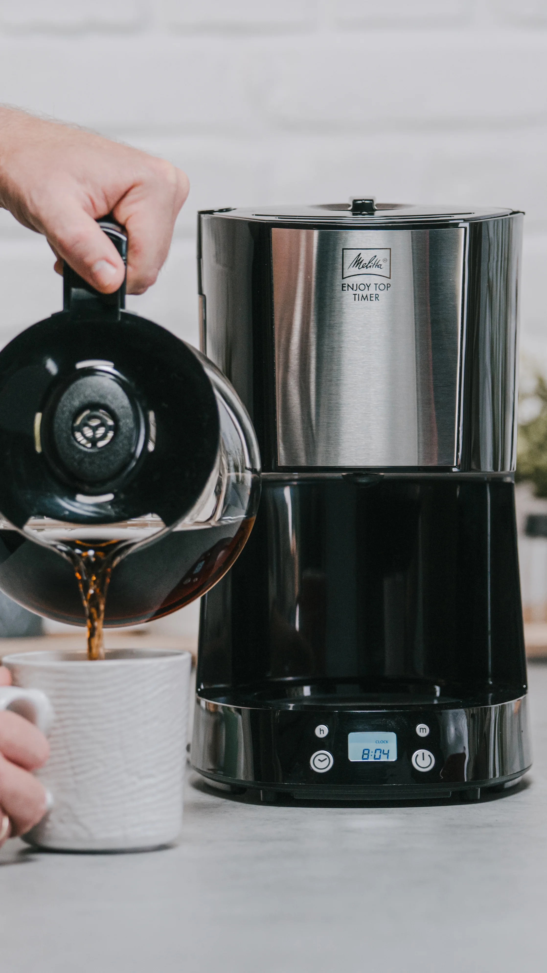 Café versé dans une tasse depuis la cafetière filtre Melitta Enjoy Top Timer avec affichage numérique