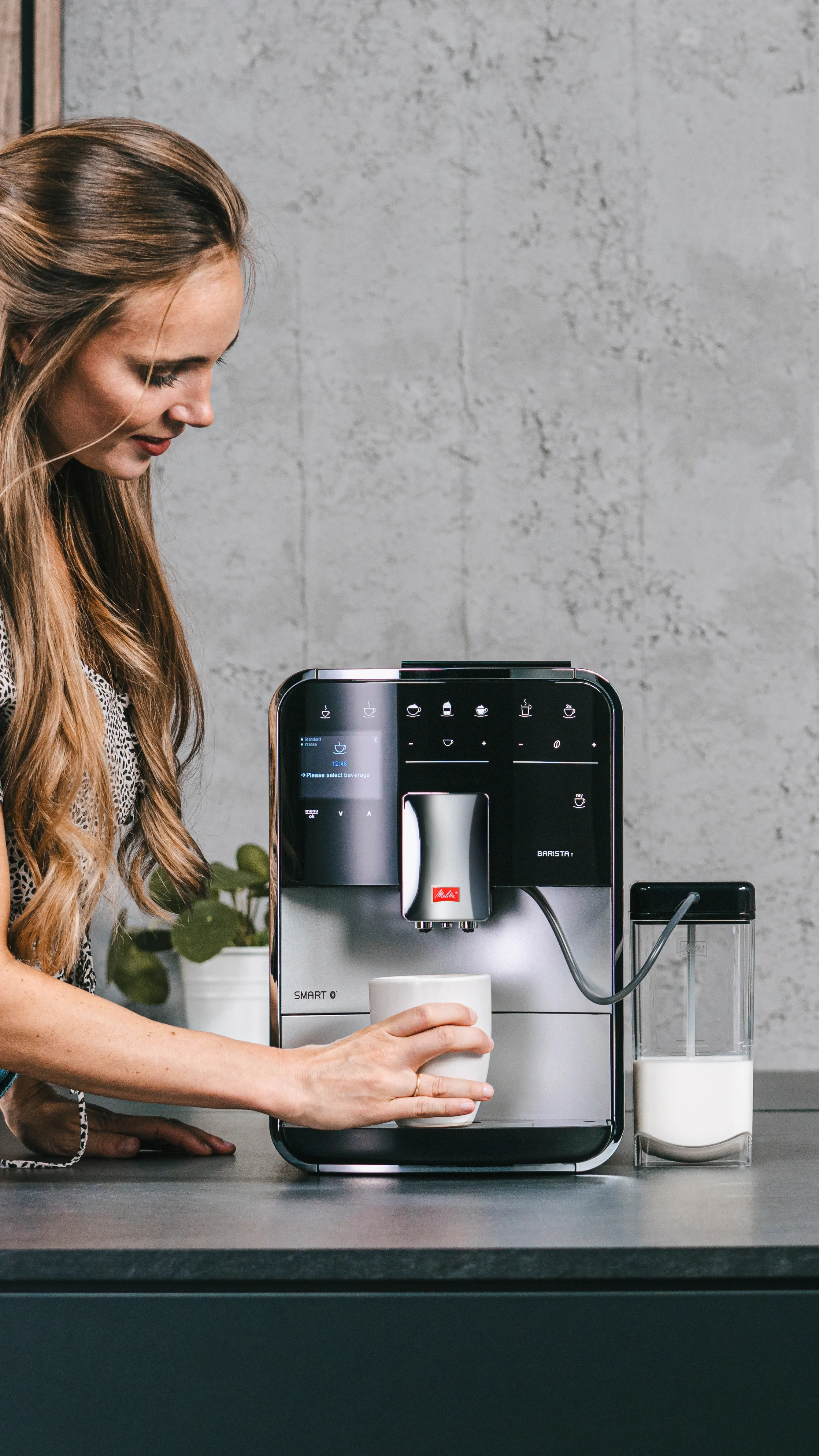 Image of a woman preparing a custom coffee thanks to our Barista T Smart automatic espresso machine.