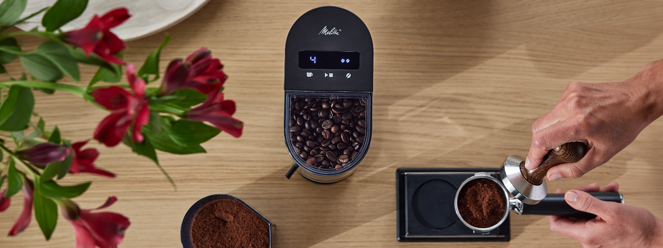 Melitta Linea® coffee grinder with coffee beans and portafilter during espresso preparation.