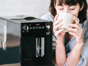 En kvinna njuter av sitt kaffe från Melitta Purista.