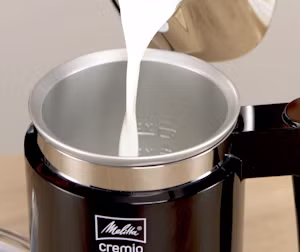 Picture of someone pouring hot milk into a creamer