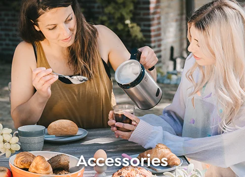 Two women sitting at a table in the garden, enjoying a coffee