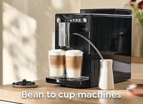 The Melitta Latticia OT is standing on a kitchen table with two latte macchiato