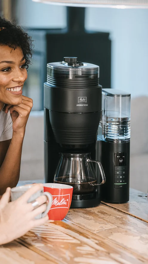 Twee mensen genieten van koffie naast het Melitta AromaFresh Pro filterkoffiezetapparaat
