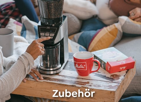 Frau mahlt Melitta Kaffee durch die Kaffeemühle neben einer Melitta Tasse