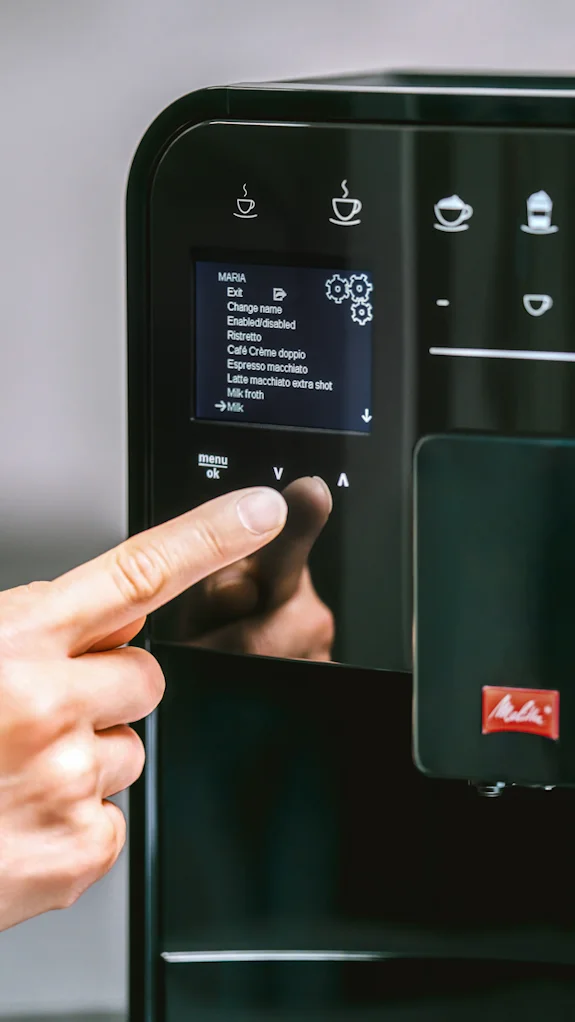 Nahaufnahme der Melitta Barista T Smart mit Finger bei der Einstellungsauswahl am Display
