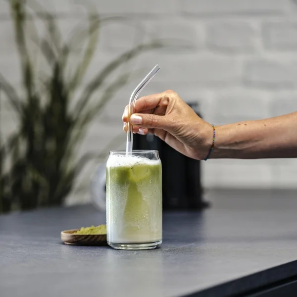 Black Melitta Cremio milk frother with a glass of delicious Matcha Latte and a straw