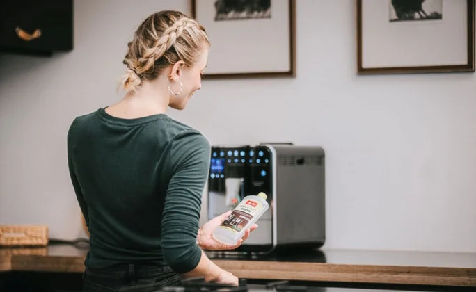 Frau mit Melitta® Entkalker Frau mit Melitta® Entkalker, Hintergrund: Melitta Barista TS Smart