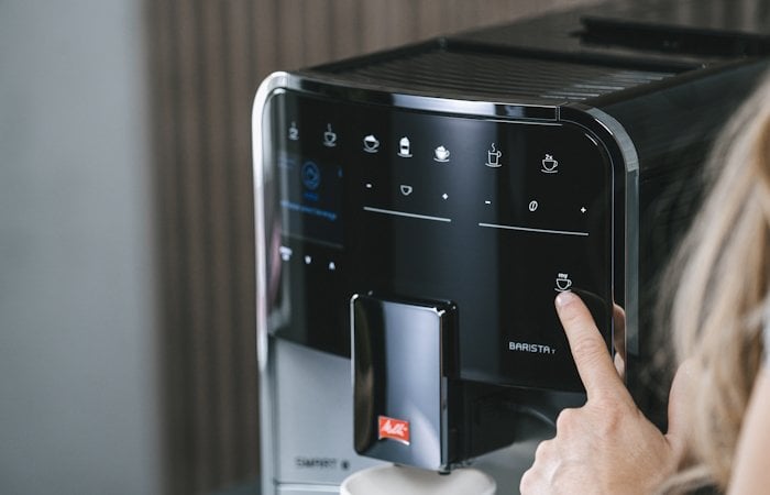 Close-up van de Melitta Barista T Smart met een vinger die een drankje kiest