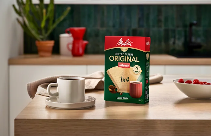 Image of a cup and one of our coffee filter boxes placed on a wooden table