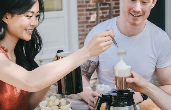 Black Melitta Cremio milk frother where lady serves milk foam