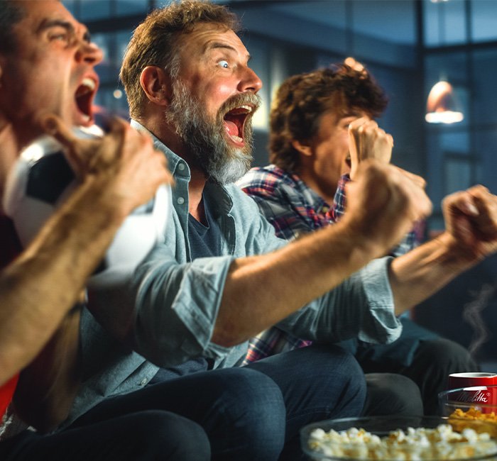 Männer freuen sich vor dem Fernseher beim Fußball
