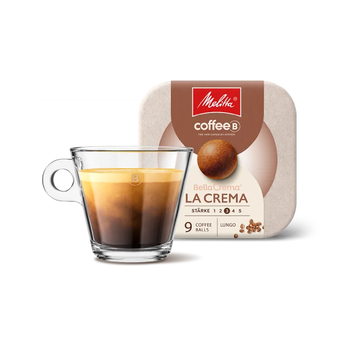 Kaffeetasse aus Glas gefüllt mit Kaffee vor Verpackung der Melitta®  BellaCrema La Crema coffeeb Verpackung