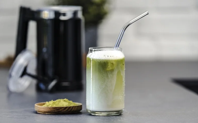 Black Melitta Cremio milk frother with a glass of delicious Matcha Latte